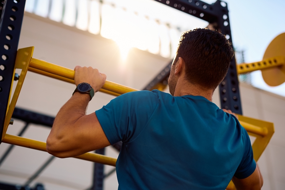 Back,View,Of,Athletic,Man,Doing,Pull ups,While,Having,Sports